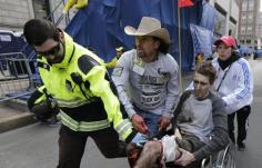 Medical responders run an injured man past the finish line the 2013 Boston Marathon following an explosion in Boston, Monday, April 15, 2013.